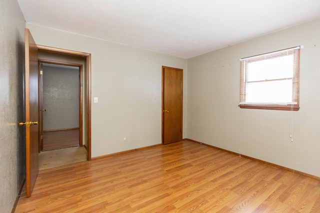 unfurnished room with light wood-type flooring