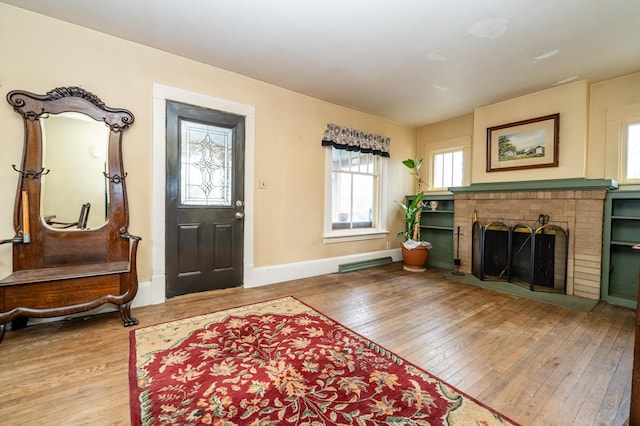 entrance foyer featuring a fireplace and wood-type flooring