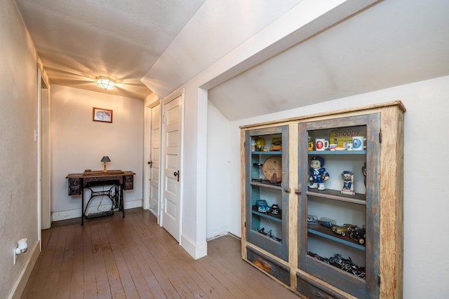 corridor featuring wood-type flooring and vaulted ceiling