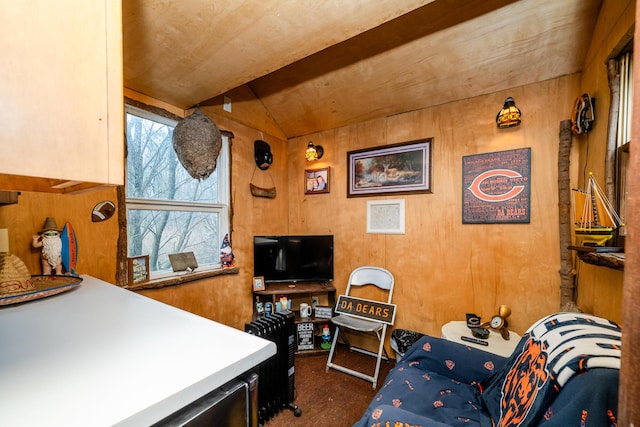 bedroom with vaulted ceiling and wood walls