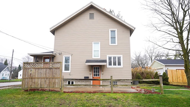 rear view of property featuring a lawn