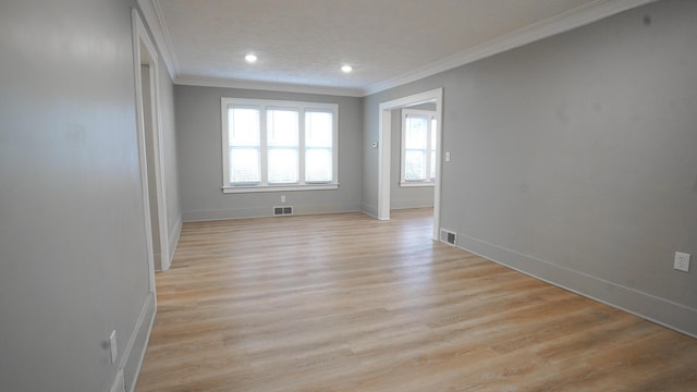 spare room featuring ornamental molding and light wood-type flooring