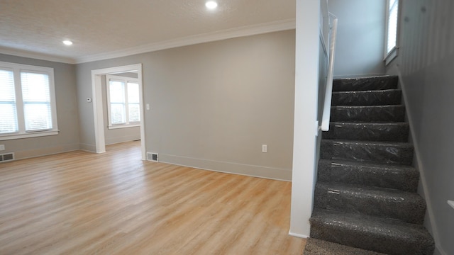 stairway featuring hardwood / wood-style flooring and ornamental molding