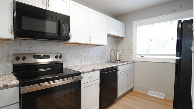 kitchen featuring sink, white cabinets, decorative backsplash, light hardwood / wood-style floors, and black appliances