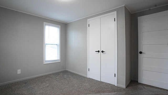 unfurnished bedroom featuring multiple windows, ornamental molding, and carpet flooring