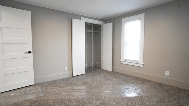 unfurnished bedroom featuring carpet floors and a closet