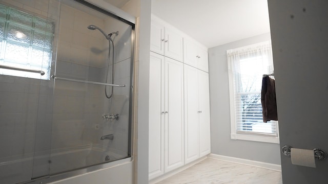 bathroom with plenty of natural light and shower / bath combination with glass door