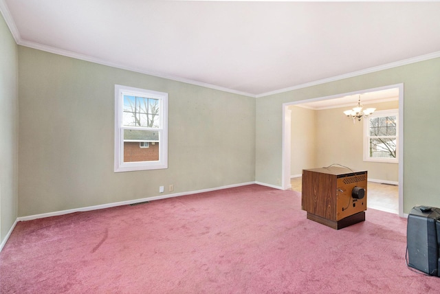 spare room featuring carpet floors, ornamental molding, and a notable chandelier