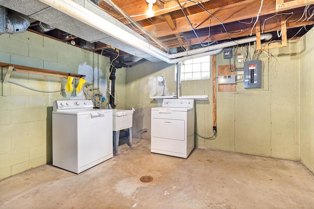 basement with washing machine and dryer, electric panel, and sink