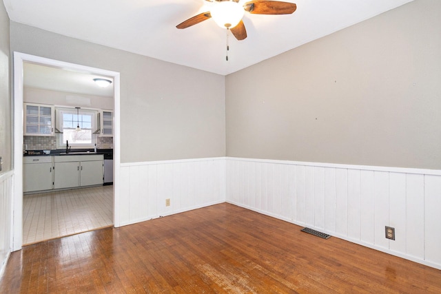 empty room featuring ceiling fan, dark hardwood / wood-style flooring, and sink