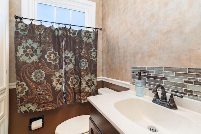 bathroom with decorative backsplash, vanity, and toilet