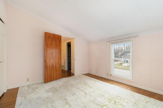 empty room with hardwood / wood-style flooring and lofted ceiling