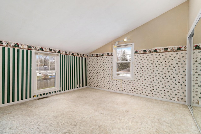 spare room with carpet flooring and lofted ceiling