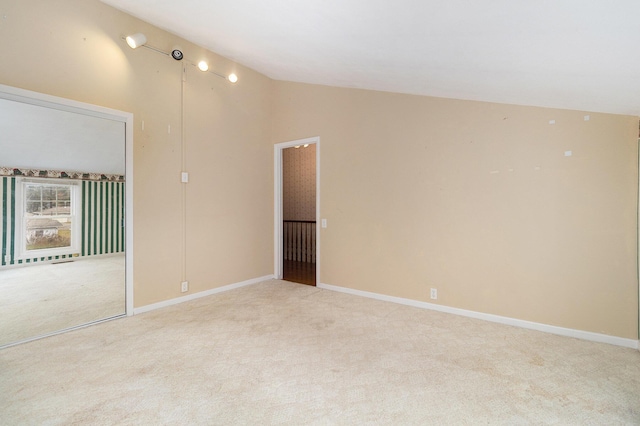 empty room with lofted ceiling and light carpet