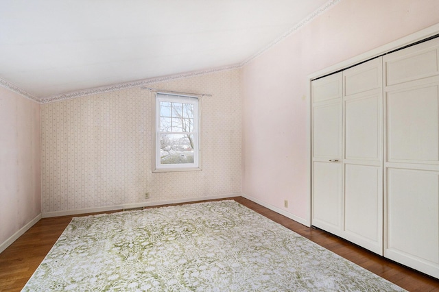 unfurnished bedroom with a closet and dark hardwood / wood-style flooring