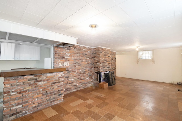 unfurnished living room with brick wall