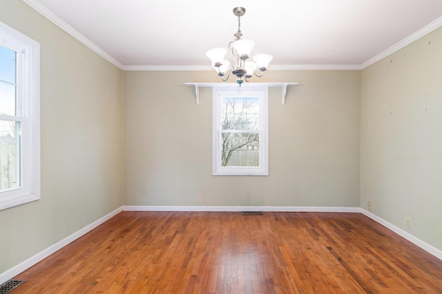 unfurnished room featuring hardwood / wood-style floors, ornamental molding, and an inviting chandelier