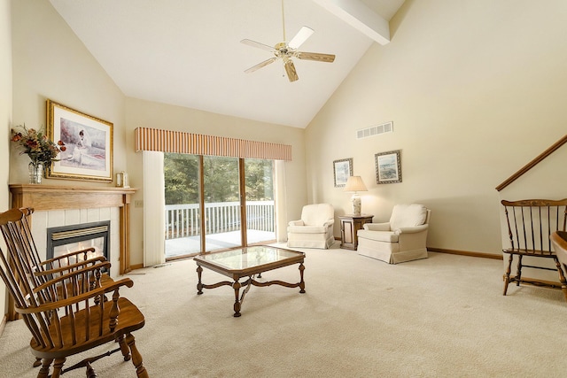 carpeted living room with a tiled fireplace, ceiling fan, beamed ceiling, and high vaulted ceiling