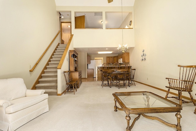 interior space with a high ceiling, light colored carpet, and an inviting chandelier