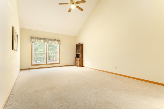 carpeted spare room with high vaulted ceiling and ceiling fan