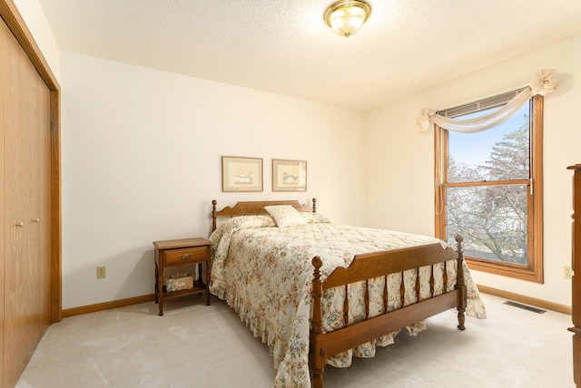 carpeted bedroom featuring a closet and a textured ceiling