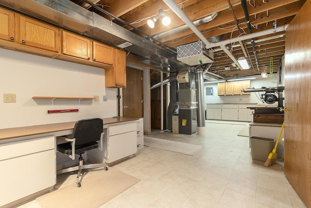 basement featuring built in desk and heating unit