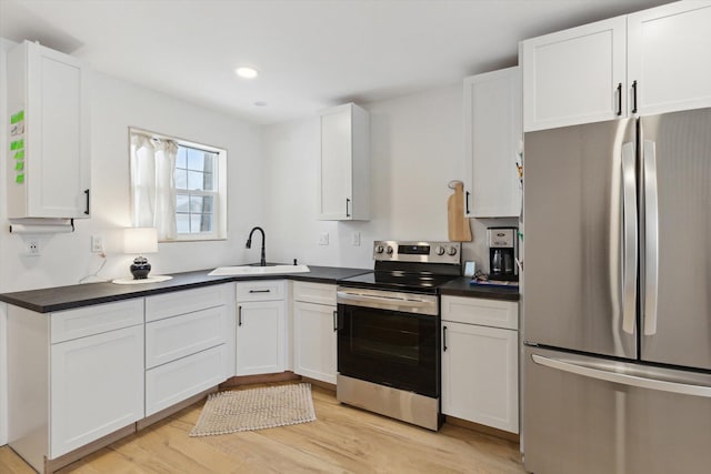 10606 Lake St, Chippewa Lake, MI 49320 - kitchen featuring stainless steel appliances, dark countertops, light wood finished floors, white cabinets, and recessed lighting