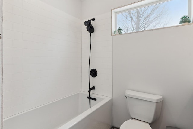 bathroom featuring toilet and tiled shower / bath combo
