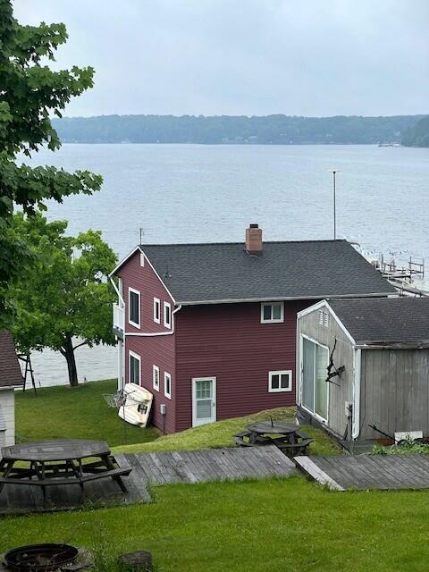 10606 Lake St, Chippewa Lake, MI 49320 - rear view of house featuring a shed, a yard, a water view, and a chimney