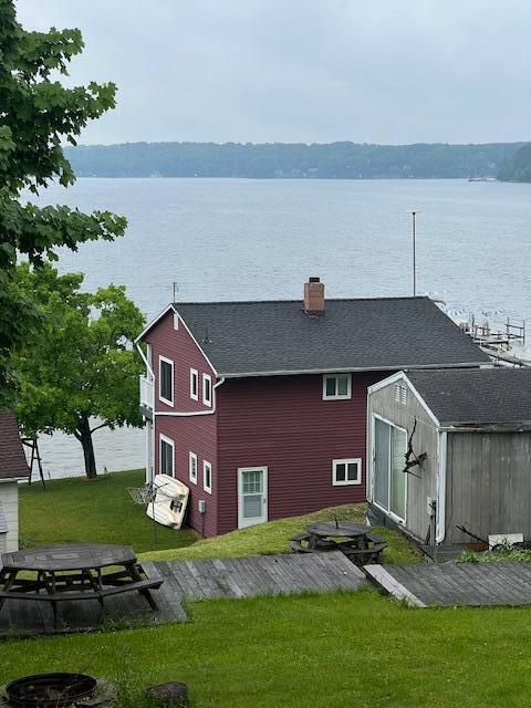 10606 Lake St, Chippewa Lake, MI 49320 - rear view of property with a storage shed, a yard, a water view, and a chimney