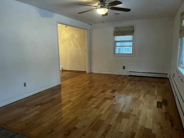 spare room with hardwood / wood-style floors, ceiling fan, and baseboard heating