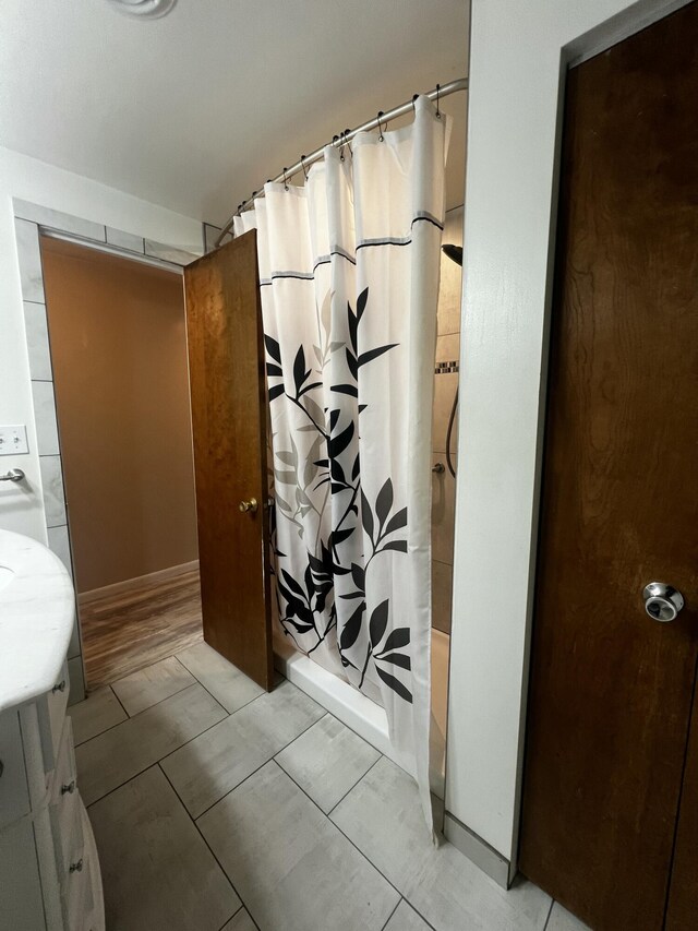 bathroom featuring wood-type flooring, vanity, and curtained shower