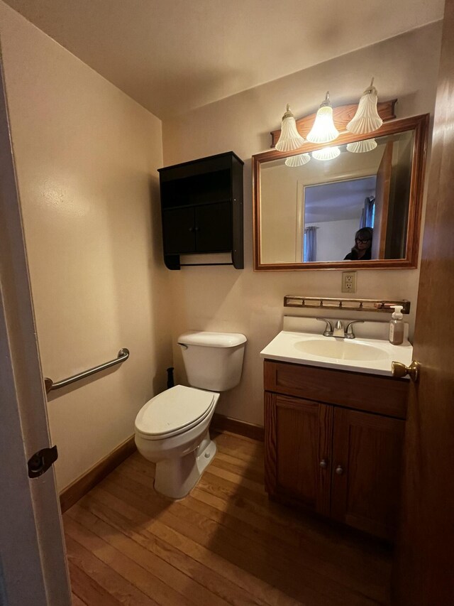 bathroom featuring wood-type flooring, vanity, and toilet