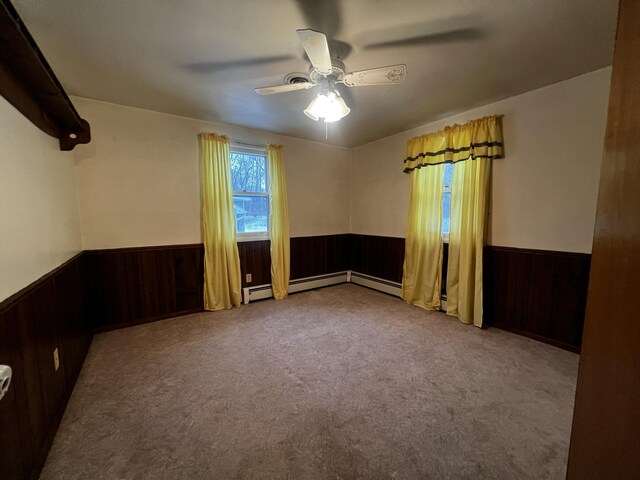 unfurnished room with light carpet, a baseboard radiator, and ceiling fan