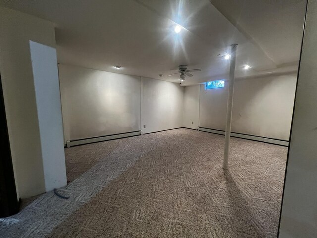 carpeted empty room with ceiling fan and a baseboard heating unit