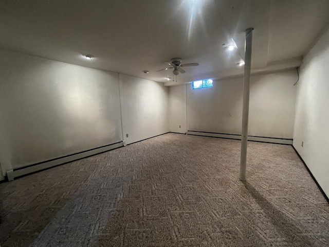 basement with carpet, ceiling fan, and a baseboard heating unit