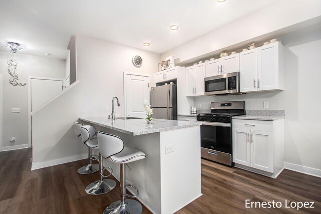 kitchen featuring white cabinetry, sink, stainless steel appliances, and light stone counters