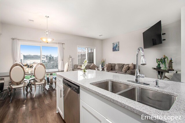 kitchen with white cabinetry, sink, light stone countertops, hanging light fixtures, and stainless steel dishwasher