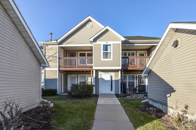 view of front of property featuring a balcony and a front yard