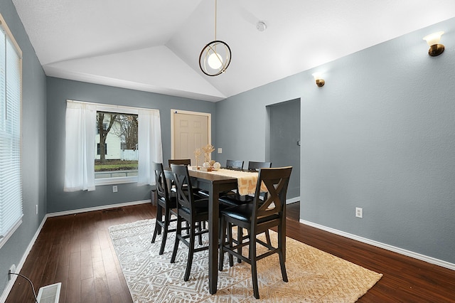 dining area with hardwood / wood-style flooring and vaulted ceiling