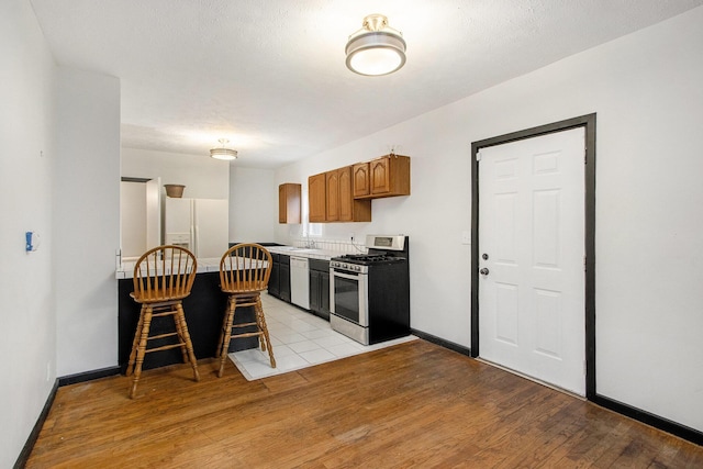 kitchen featuring sink, light hardwood / wood-style floors, and white appliances