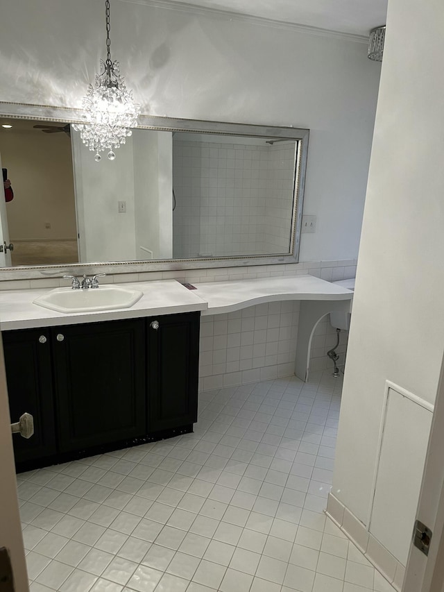 bathroom featuring tile patterned floors, a relaxing tiled tub, vanity, and an inviting chandelier