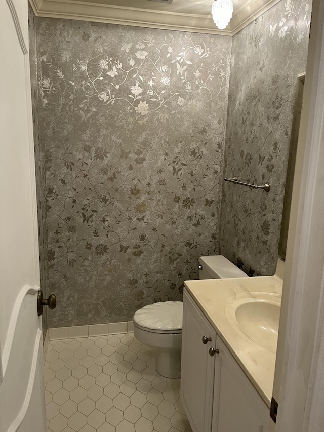 bathroom with tile patterned floors, vanity, toilet, and ornamental molding