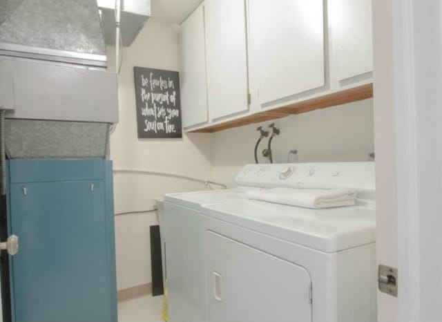 clothes washing area with washer and clothes dryer and cabinets