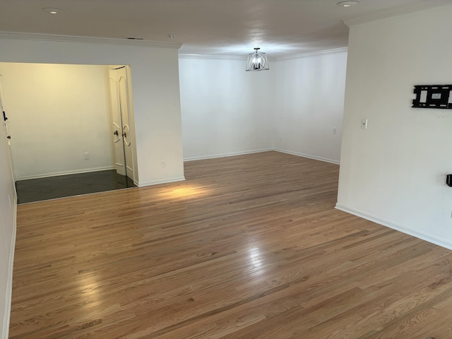 unfurnished room featuring visible vents, crown molding, baseboards, and wood finished floors