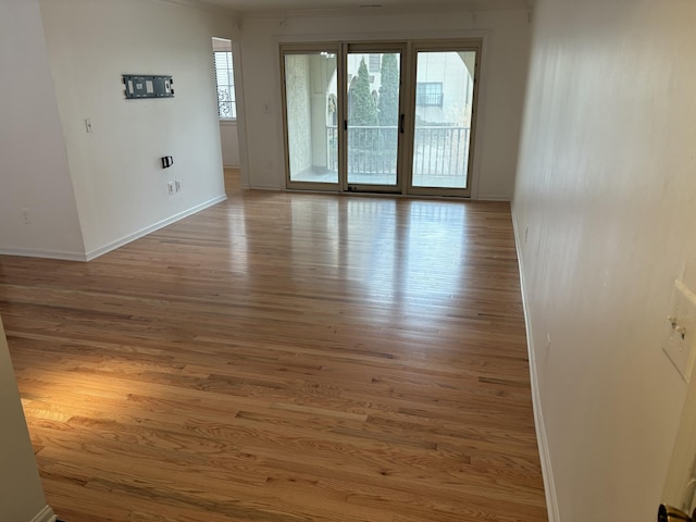 unfurnished room with light wood-style flooring and baseboards