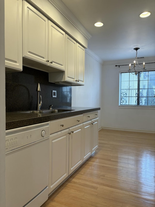 kitchen with dishwasher, dark countertops, backsplash, crown molding, and a sink