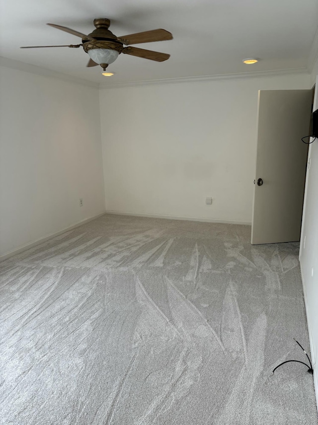 spare room featuring ornamental molding, light colored carpet, and ceiling fan