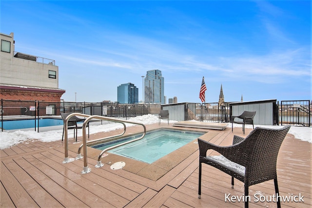 view of swimming pool featuring an in ground hot tub and a deck