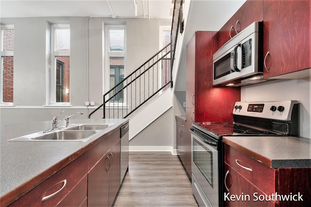 kitchen featuring light wood-type flooring, sink, and appliances with stainless steel finishes